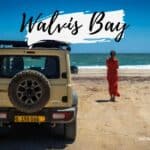 Une voiture 4x4 sur la plage de Walvis Bay, une femme regarde l'océan.