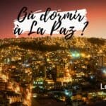 Vue nocturne de La Paz avec ville illuminée et montagnes en arrière-plan.