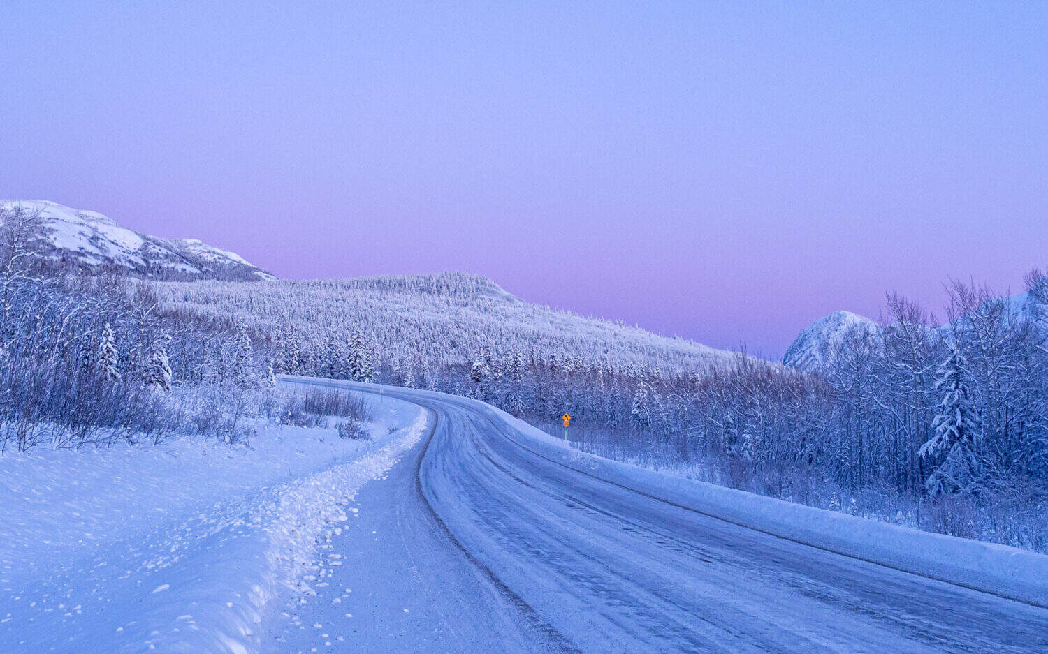 Coucher de soleil rose sur un lac gelé du Yukon