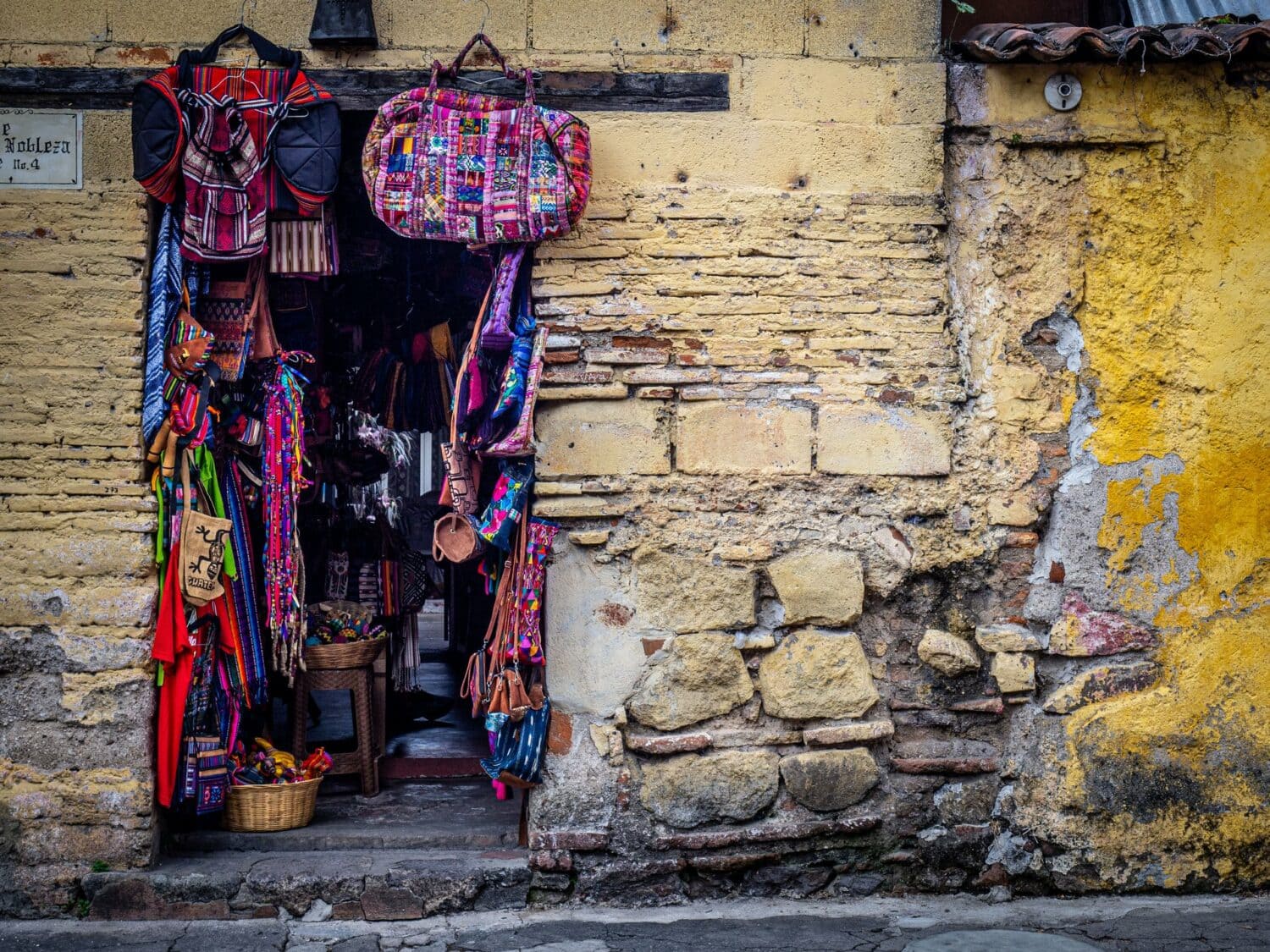 Boutique de sacs et textiles mayas dans un vieux mur de pierre à Antigua