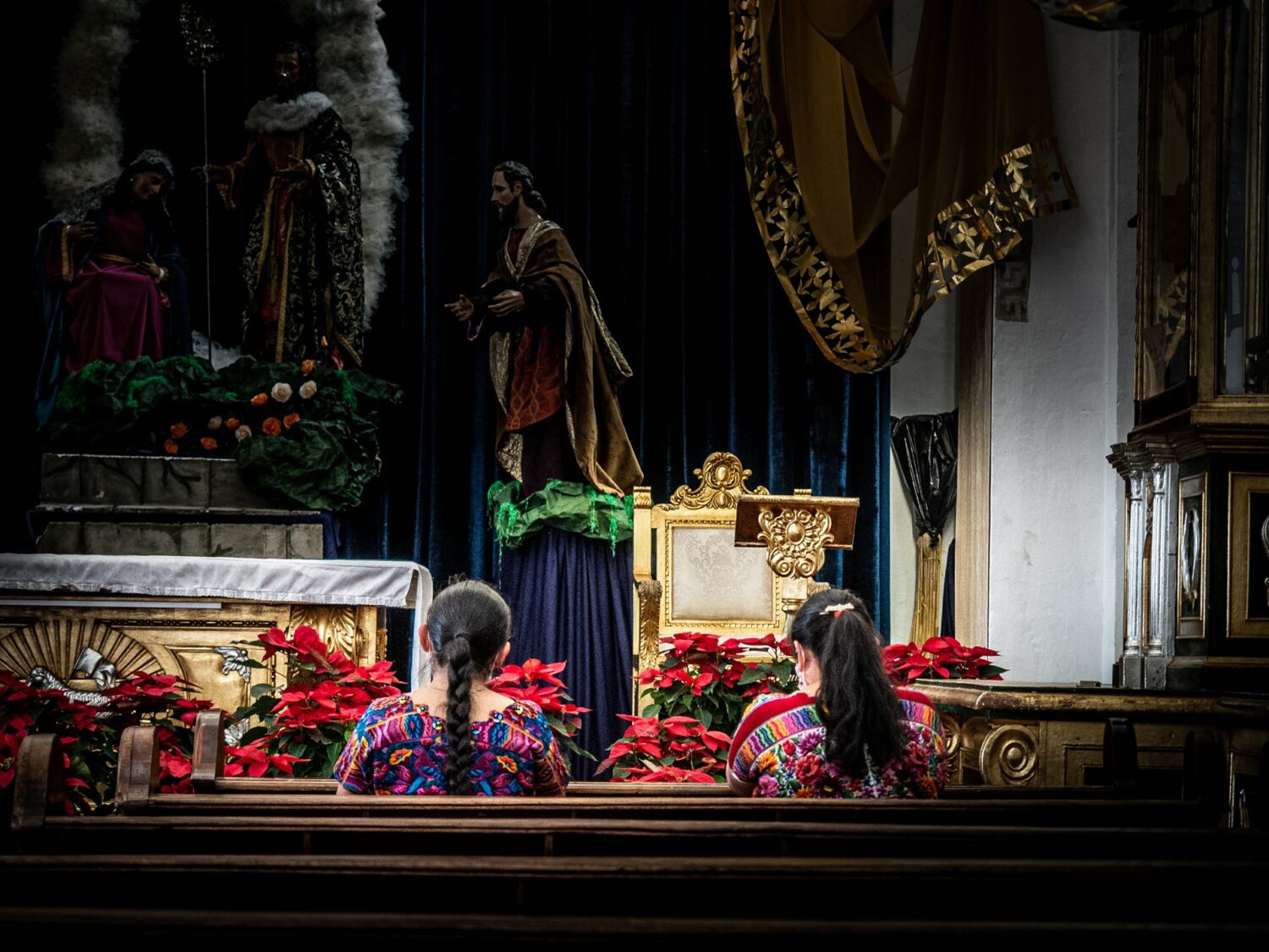 Deux femmes en tenue traditionnelle priant dans une église d’Antigua Guatemala