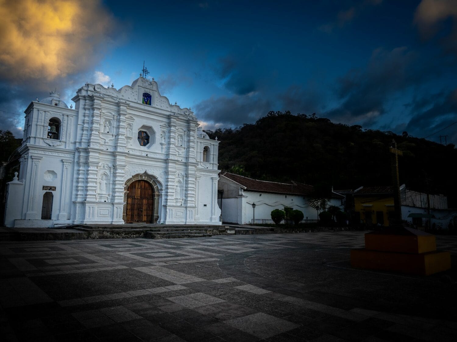 Église blanche d’Antigua Guatemala au crépuscule, au bout d’une place pavée