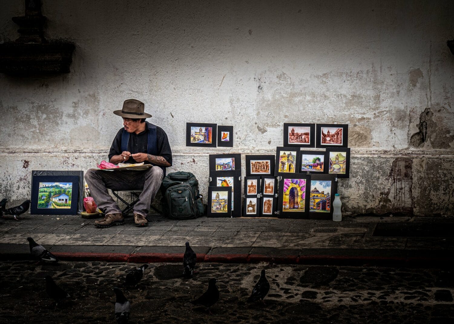 Peintre vendant ses tableaux sur un trottoir d’Antigua Guatemala