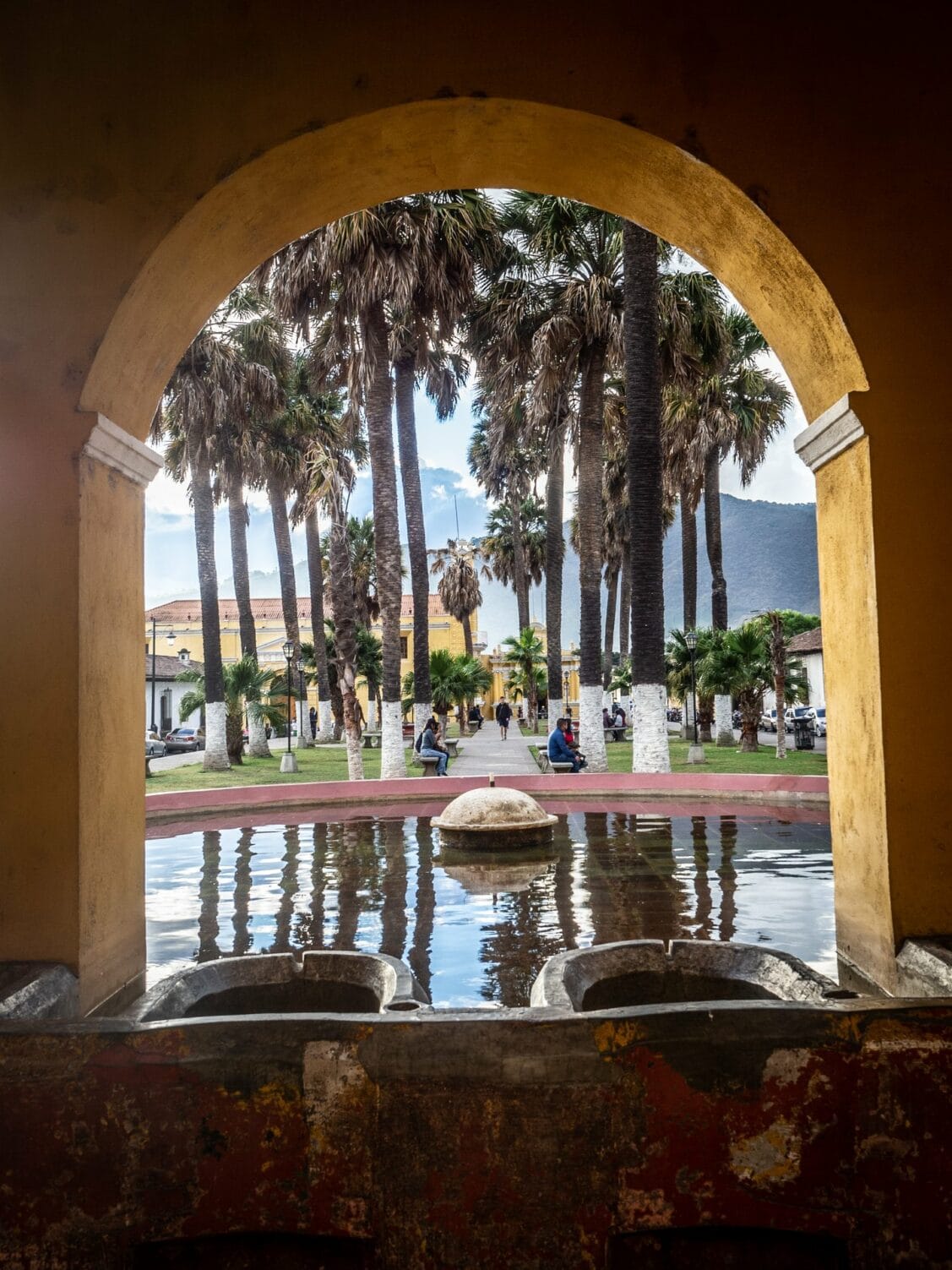 Vue sur le parc et les palmiers à travers une arcade du Tanque de la Unión