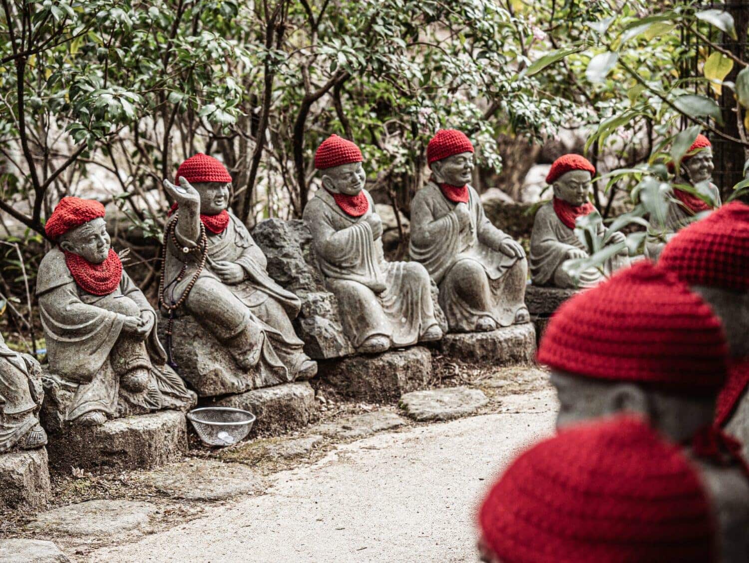 Statues de pierre aux bonnets rouges au temple Daisho-in