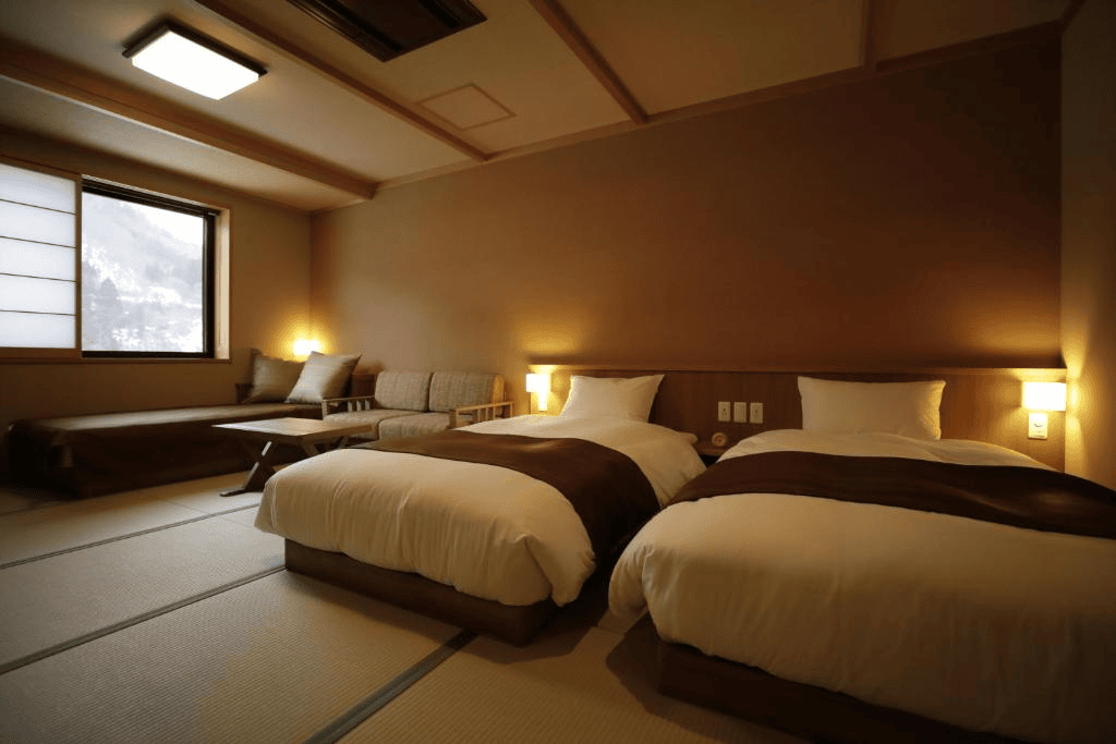 Chambre moderne avec deux lits, éclairage doux, vue sur la montagne.