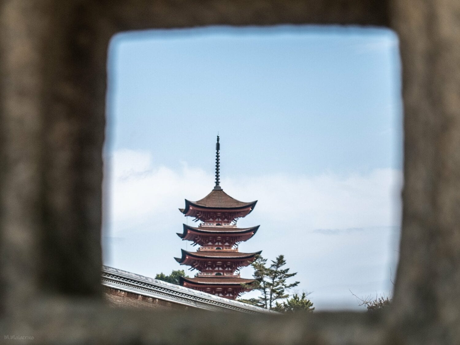 La pagode à cinq étages de Miyajima vue à travers une lanterne de pierre