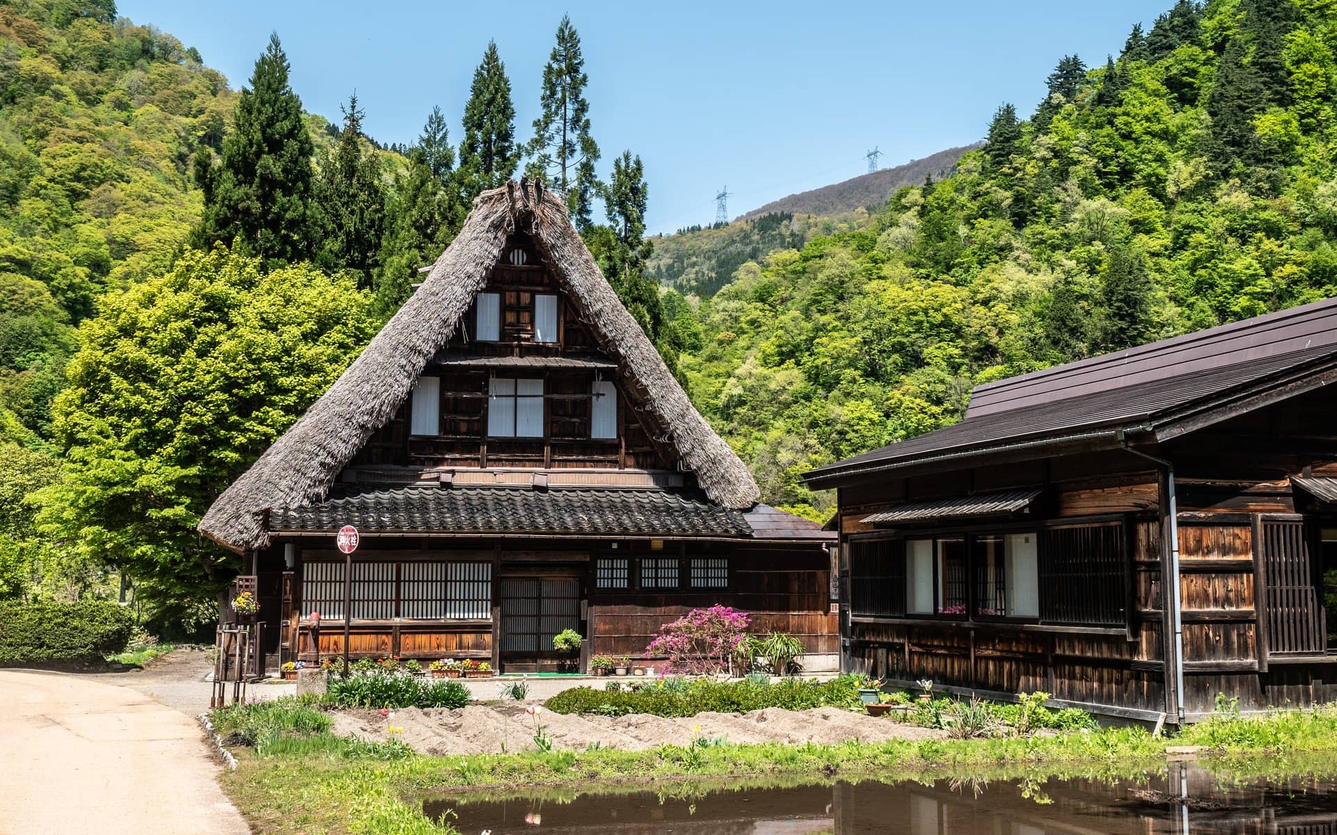 Maison au toit de chaume et rizière en eau à Suganuma
